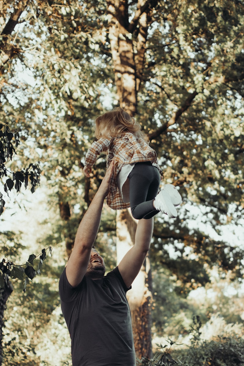a person holding a child on the back in a tree