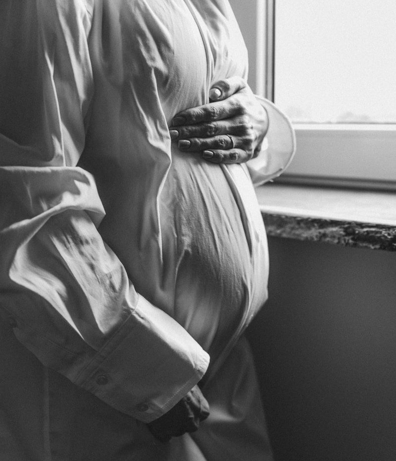 a pregnant woman standing in front of a window