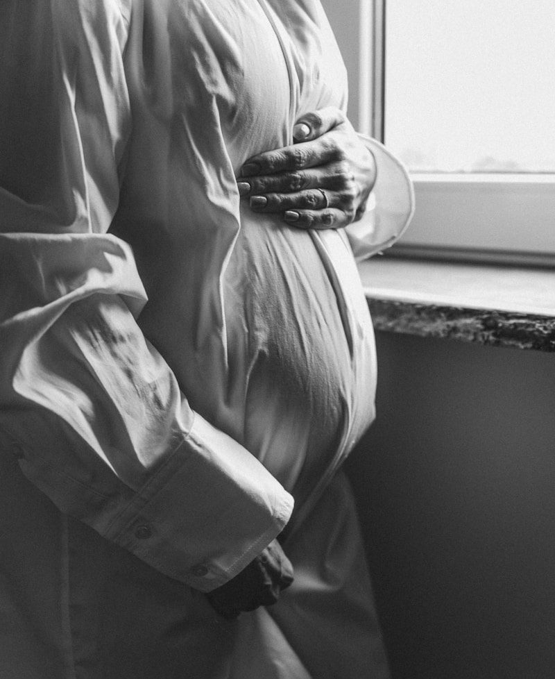 a pregnant woman standing in front of a window